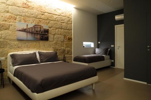Pane e Pomodoro في باري: غرفة نوم بسرير وجدار حجري