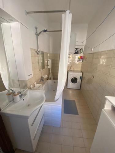 a white bathroom with a sink and a shower at Apartman Mila - free parking and WiFi in Rijeka