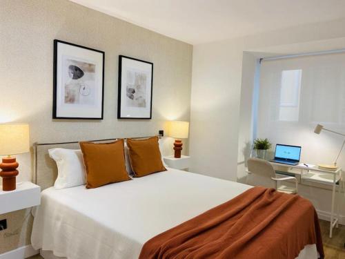 a bedroom with a bed and a desk with a laptop at Centric Lovely private flat 2BD, 2BH + AC in Madrid
