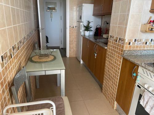 une petite cuisine avec un comptoir et un évier dans l'établissement Acogedor Apartamento, à Almerimar