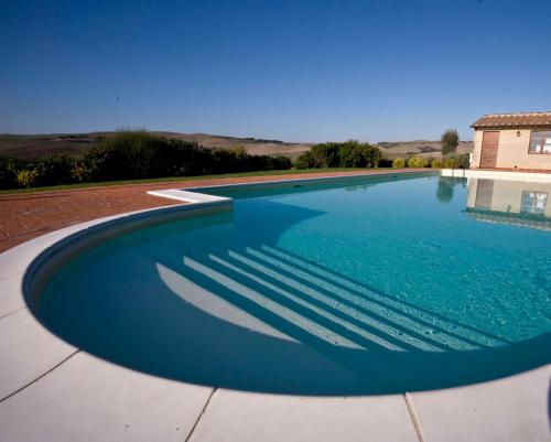 a large swimming pool with blue water at PODERE LE VOLPAIE in Montecatini Val di Cecina