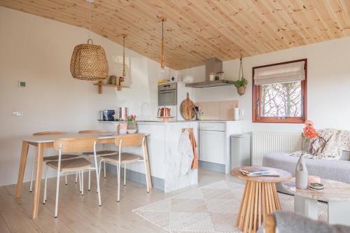 a kitchen and a living room with a table and chairs at Leva - Logeren in Drenthe in Doldersum