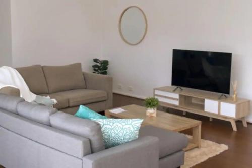 a living room with a couch and a flat screen tv at Vitamin Sea by the Beach by Ready Set Stay in Cowes