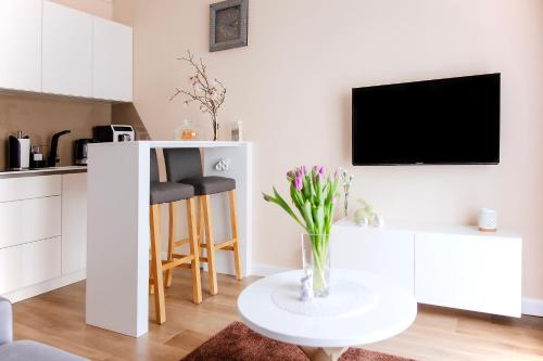 a living room with a vase of flowers on a table at Apartament Bimba - Free Parking in Poznań