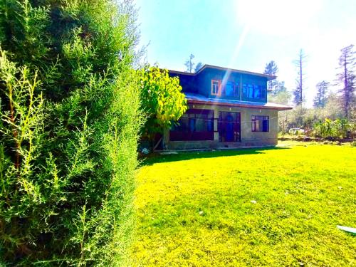 uma casa com um jardim verde em frente em Sheraz palace em Tangmarg