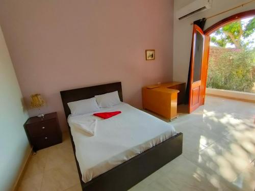 um quarto com uma cama com uma toalha vermelha em Cleopatra House em Luxor