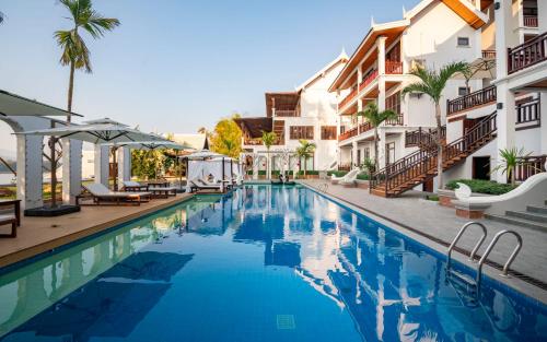 a swimming pool in front of some buildings at Relaxful Hotel泊岸酒店 in Luang Prabang
