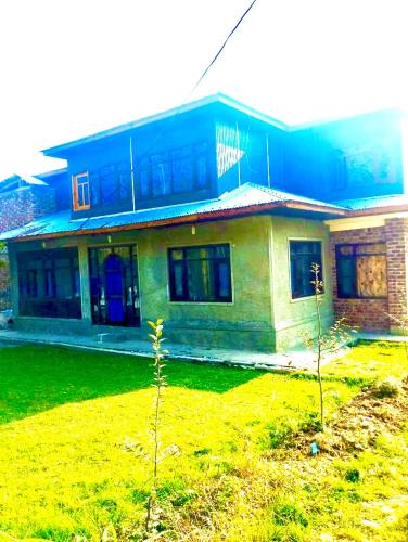 ein Haus mit grünem Rasen davor in der Unterkunft Sheraz palace in Tangmarg