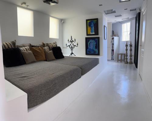 - un salon avec un grand lit dans une pièce blanche dans l'établissement Sunny Penthouse With Sea View, à Barcelone
