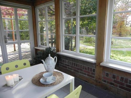 - une table avec un vase dans une chambre avec des fenêtres dans l'établissement Zwei-Zimmer-Wohnung mit Wintergarten, à Dömitz