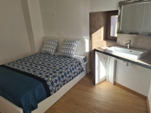 une petite chambre avec un lit et un lavabo dans l'établissement 20 Min Disneyland / 30 Min Paris, à Thorigny-sur-Marne