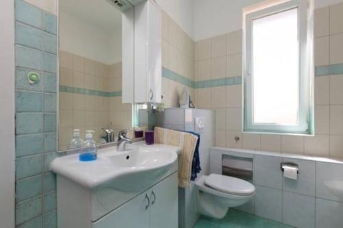 a bathroom with a sink and a toilet and a window at Studio mit Balkon für zwei Personen - b56476 in Split