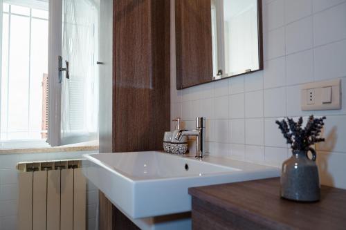 bagno con lavandino bianco e specchio di La Stanza di Isabel a Massa Marittima