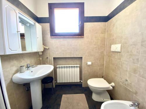 łazienka z umywalką, toaletą i oknem w obiekcie Unabhaengige Wohnung in Sirmione mit Eigener Terrasse w Sirmione