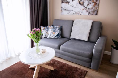 a living room with a couch and a table with flowers at Apartament Bimba - Free Parking in Poznań