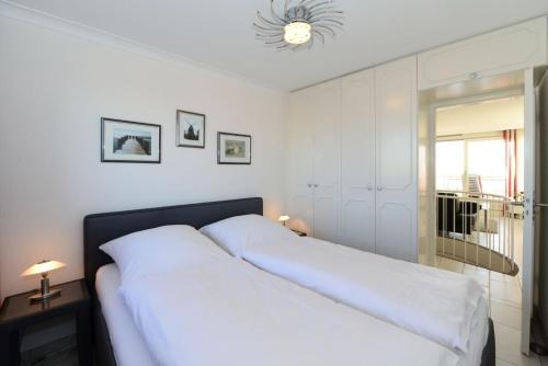 ein Schlafzimmer mit einem großen Bett mit weißer Bettwäsche in der Unterkunft Haus Bi de Wyk D6A in Wyk auf Föhr