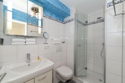 ein Bad mit einem WC, einem Waschbecken und einer Dusche in der Unterkunft Haus Bi de Wyk D6A in Wyk auf Föhr