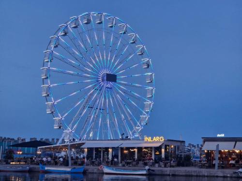 a large ferris wheel in a city at night at Ama Boutique in Constanţa