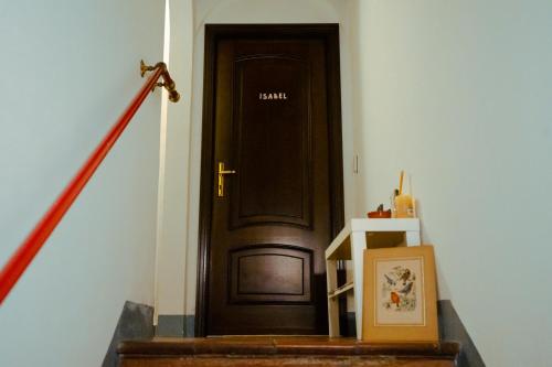 una porta nera con un cartello in un corridoio di La Stanza di Isabel a Massa Marittima