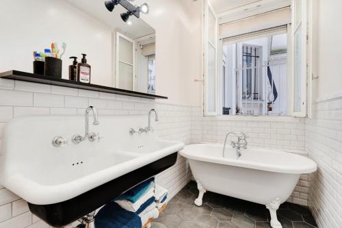 a white bathroom with two sinks and a tub at JO - Appartement porte maillot Paris 16 - 4P in Paris
