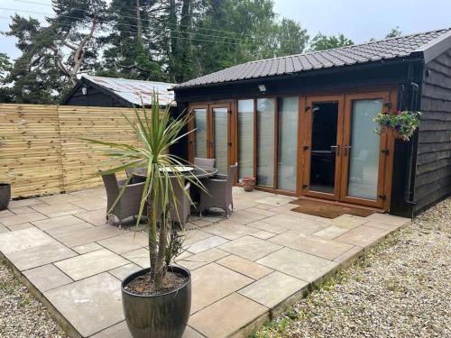 a potted plant sitting on a patio in front of a house at Converted barn one bedroom studio glamping in Horspath