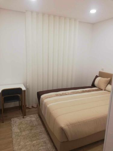 a bedroom with a bed and a chair in it at Casa de São Miguel in Mirandela