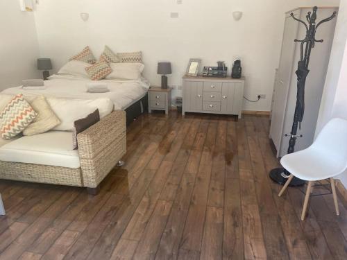 a bedroom with a bed and a wooden floor at Converted barn one bedroom studio glamping in Horspath