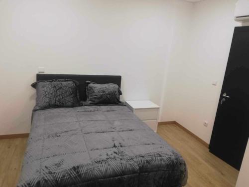 a bedroom with a bed with a gray comforter at Casa de São Miguel in Mirandela