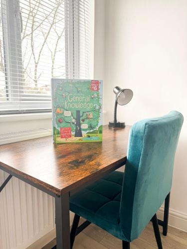 um livro sentado em cima de uma mesa de madeira com uma cadeira em London Oasis Retreat - Central 2BR Apartment park em Hendon