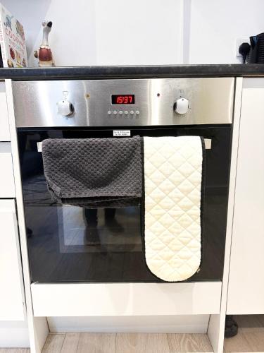 um forno de cozinha com duas toalhas penduradas em London Oasis Retreat - Central 2BR Apartment park em Hendon