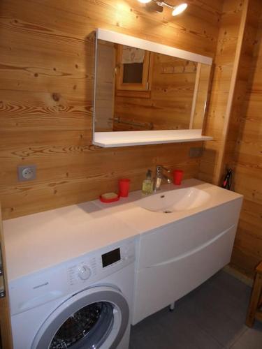 une salle de bain avec une machine à laver et un lavabo dans l'établissement L'ESCACHELLE, à Les Déserts
