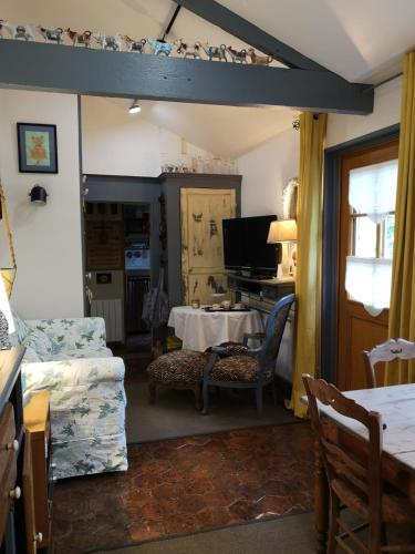 - un salon avec une table, un canapé, une table et des chaises dans l'établissement Villa le Cloky, à Thomery