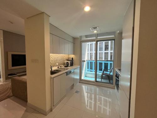 a kitchen with a large window and a kitchen with a sink at DAMAC Voleo In Business Bay in Dubai