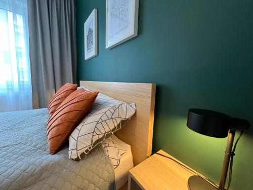 a bedroom with a bed with two pillows and a lamp at Apartament Fordon Przy Politechnice Bydgoskiej in Bydgoszcz