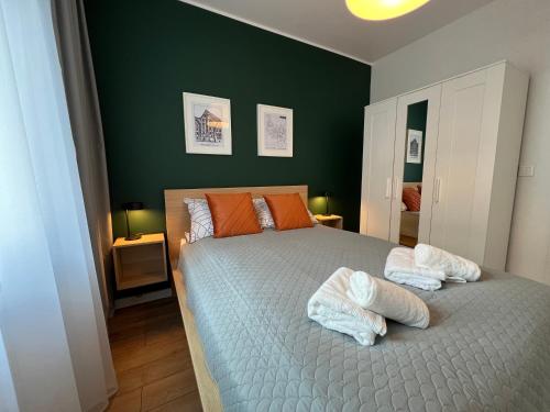 a bedroom with a bed with two towels on it at Apartament Fordon Przy Politechnice Bydgoskiej in Bydgoszcz
