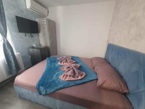 a bed with two clothes on it in a room at Ama Boutique in Constanţa