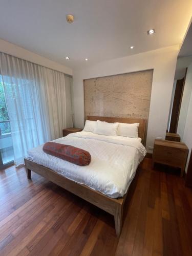 um quarto com uma cama grande e piso em madeira em WERT em Cidade Phuket