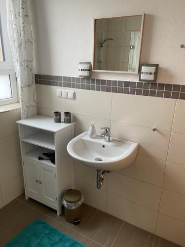 a bathroom with a sink and a mirror at Ferienwohnung Oma Else in Offenheim