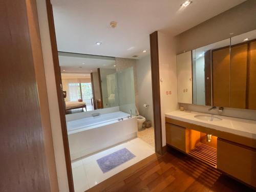 a bathroom with a tub and a large mirror at WERT in Phuket Town