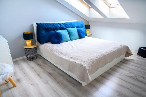 1 dormitorio con 1 cama grande con almohadas azules en Apartament EcoPure Tychy en Tychy