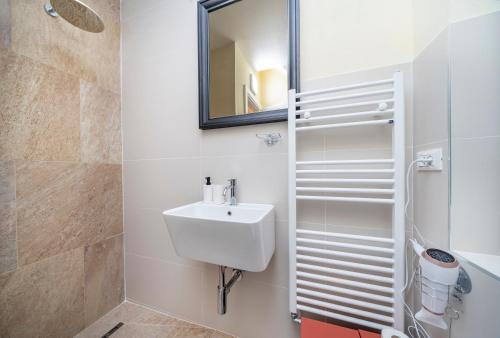 uma casa de banho com um lavatório e um espelho em Chic Retreat em Trieste