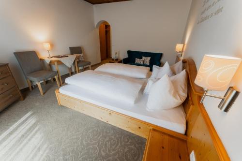 a bedroom with a bed and a table and chairs at Pension Zirbenhof in Ramsau am Dachstein