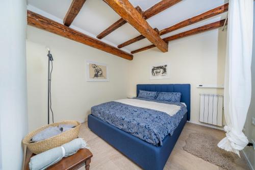 um quarto com uma cama azul e tectos em madeira em Chic Retreat em Trieste