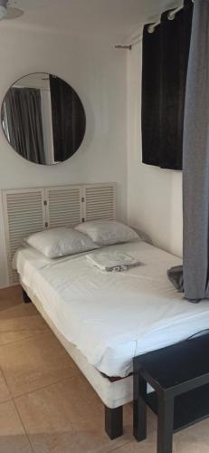 - un lit dans une chambre avec un miroir mural dans l'établissement STUDIO AGREABLE, à Montpellier