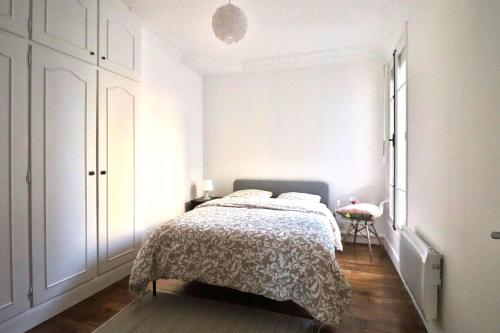 ein weißes Schlafzimmer mit einem Bett und einem Fenster in der Unterkunft Escale Urbaine: Confort & Métro à 2 Pas in Saint-Ouen