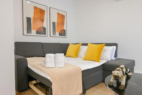 een woonkamer met een bank met gele kussens bij For You Rentals Amplia Casa Madrid de 3 Dormitorios M (VLM4) in Madrid