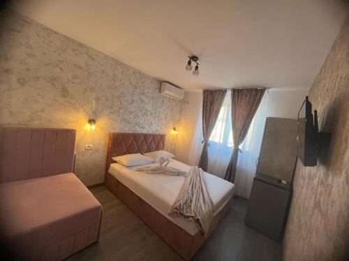 ein kleines Schlafzimmer mit einem Bett und einem Fenster in der Unterkunft Ama Boutique in Constanţa