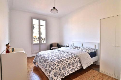 ein weißes Schlafzimmer mit einem Bett und einem Fenster in der Unterkunft Escale Urbaine: Confort & Métro à 2 Pas in Saint-Ouen