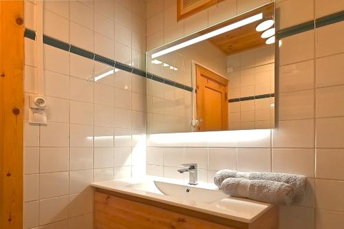 een badkamer met een wastafel en een spiegel bij Le Cocoøn - Appt vue montagne in La Bresse
