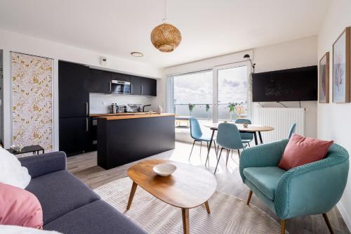 un salon avec un canapé, des chaises et une table dans l'établissement Nouveau - Le crépuscule, à Saint-Herblain